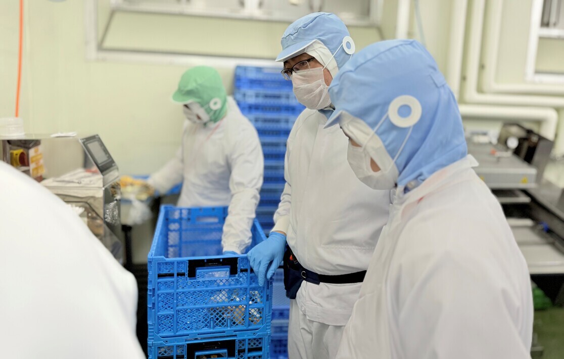 K.Cさんが同僚と仕事の会話している写真